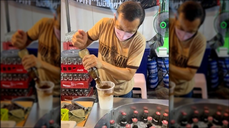 Thai man making bottled Coke slushie