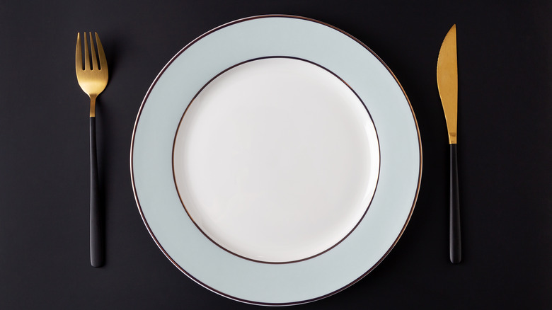 Plate and silverware on black table