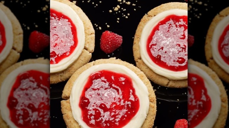 three raspberry cheesecake cookies on a black background