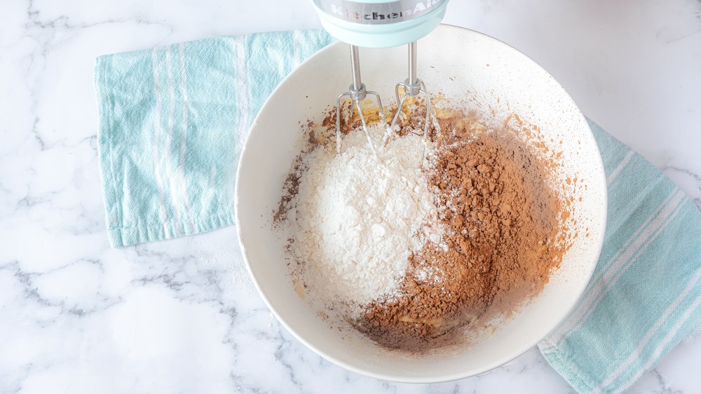 adding dry ingredients to rich double chocolate chip cookies