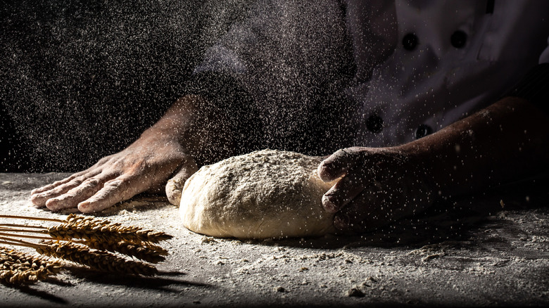 baker crafting pizza dough by hand