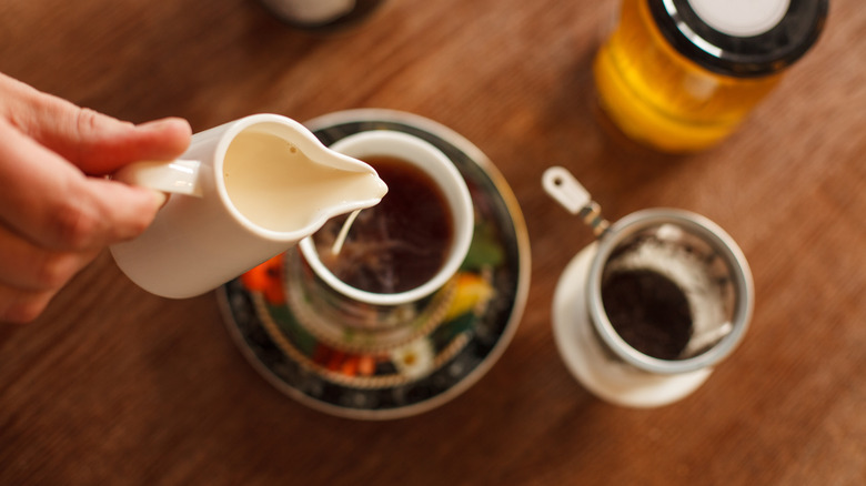 pouring milk in steeped tea