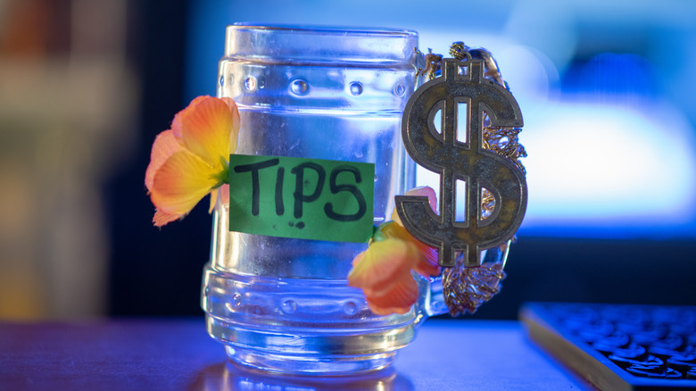 Empty tip jar decorated with flowers and dollar sign