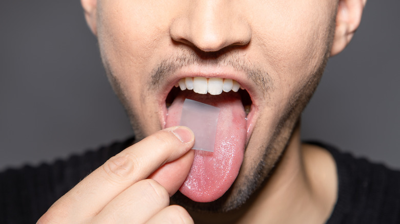 man places breath strip tongue