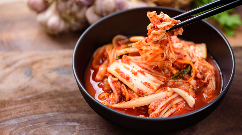 Kimchi in black bowl chopsticks
