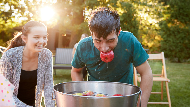 teen boy bobbing for apples