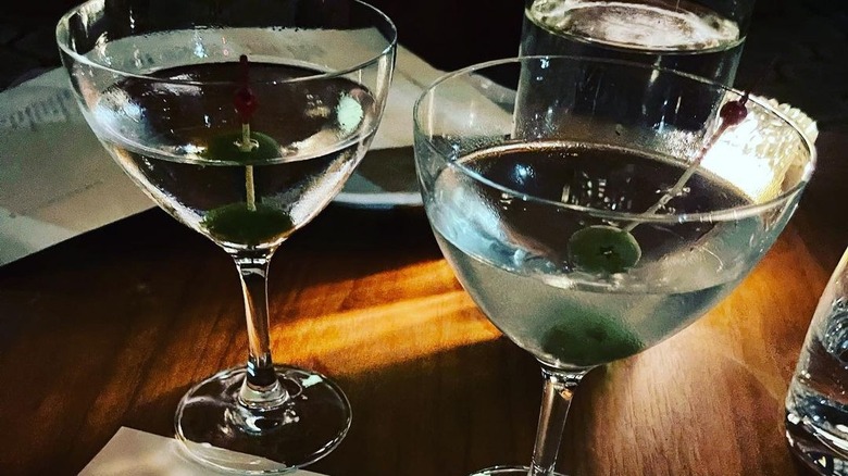 Two martinis with olives in glasses