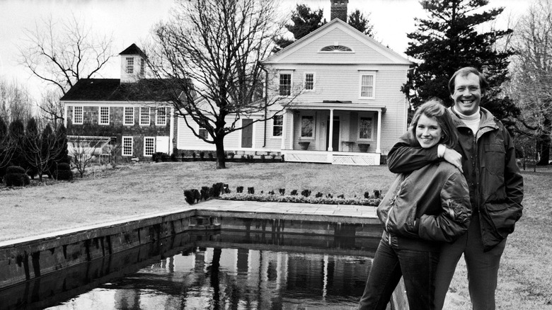 Martha Stewart and Andrew Stewart pose in front of house