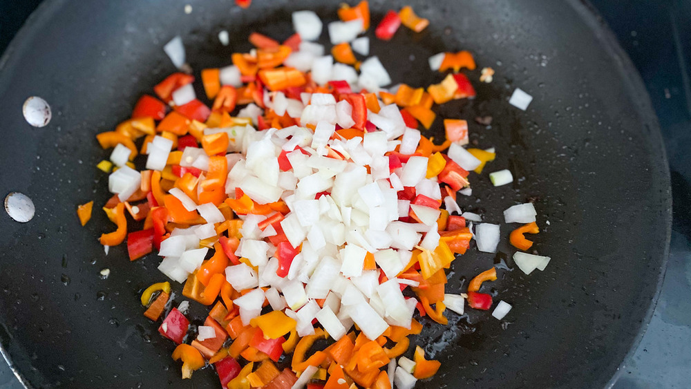 onions and peppers cooking in skillet for sausage breakfast casserole