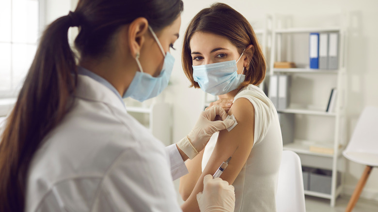  A doctor gives a young woman a shot