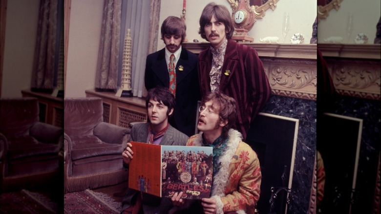 The Beatles hold up the album cover for Sgt. Pepper's Lonely Hearts Club Band