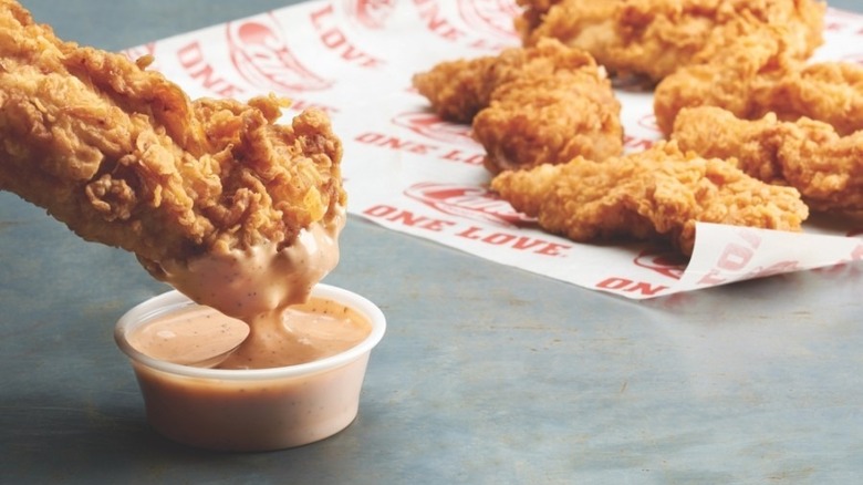 Chicken finger dipped in Cane's sauce