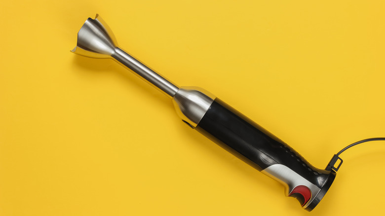 immersion blender against a yellow backdrop