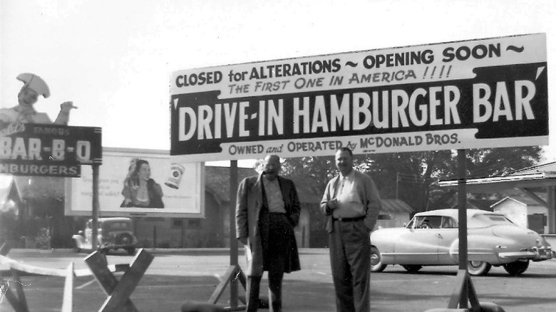 Two brothers standing in front of a grey and white sign