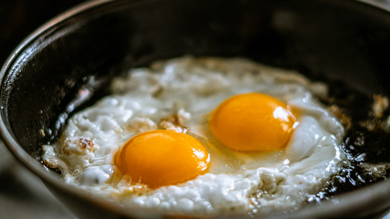 Two eggs frying in a pan 