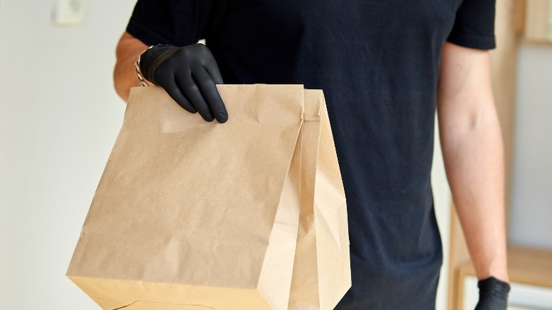 Person holding bag of food to go