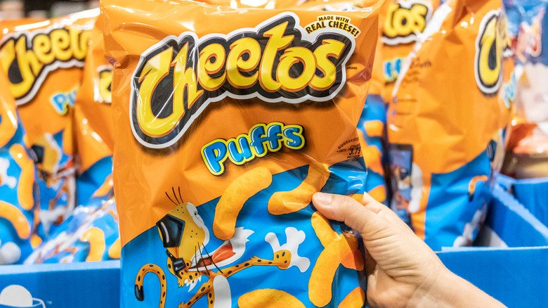 Customer holding a bag of Cheetos Puffs