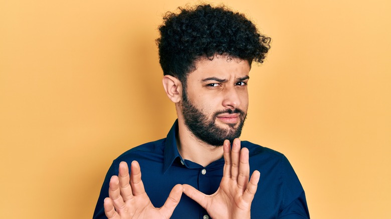 Man showing disgust on a yellow background