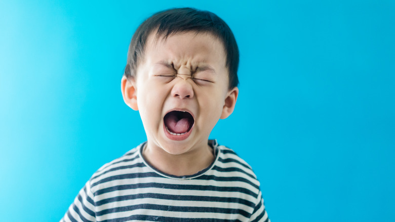 An unhappy person against a blue background