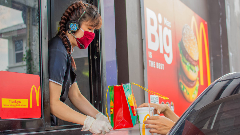 McDonald's worker serves food in the drive through 