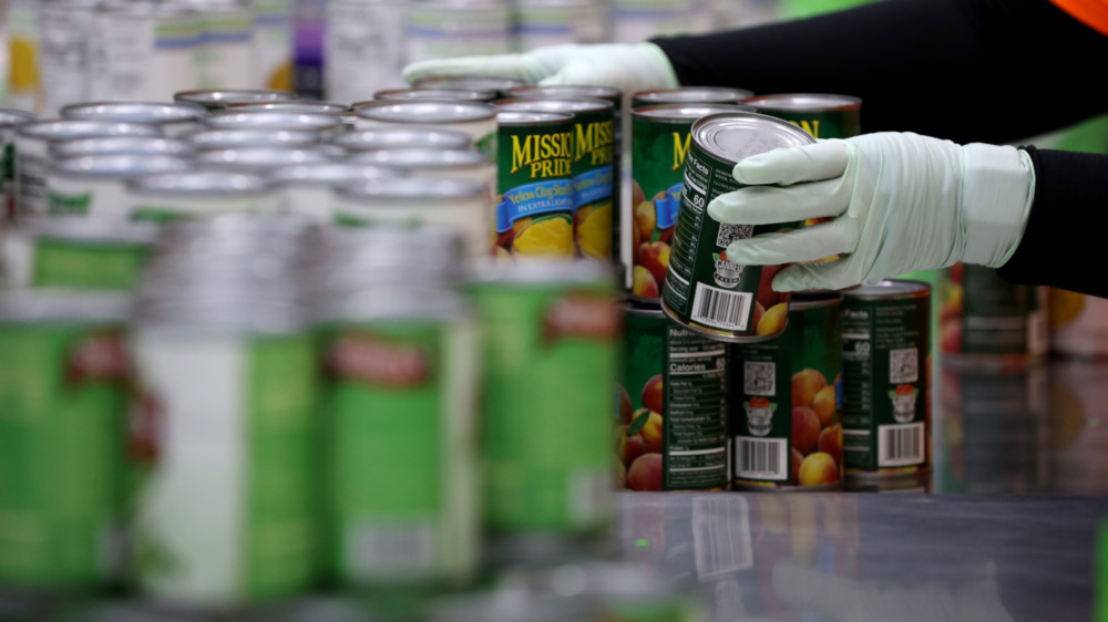 Hands stacking canned food