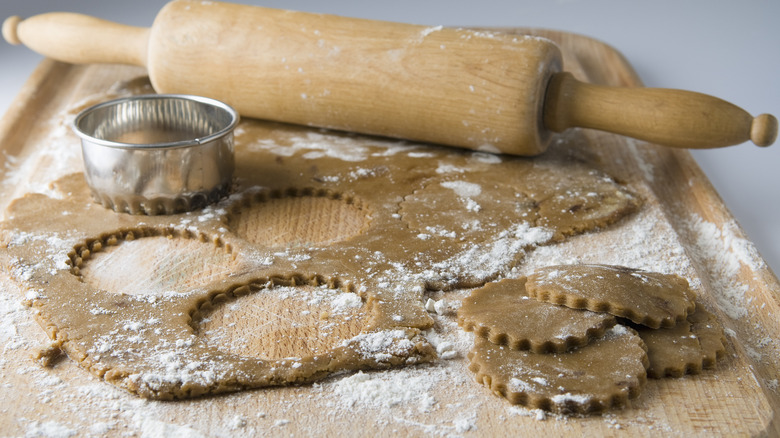 unbaked gingerbread and cookie cut-outs, rolling pin