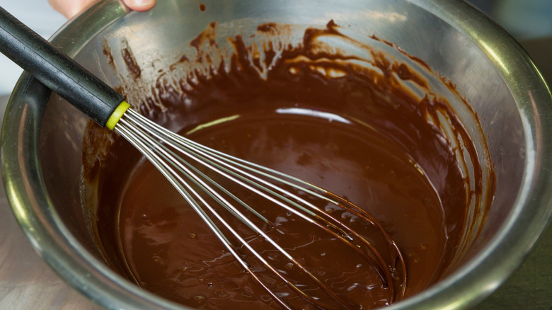 Bowl with melted cocoa and whisk