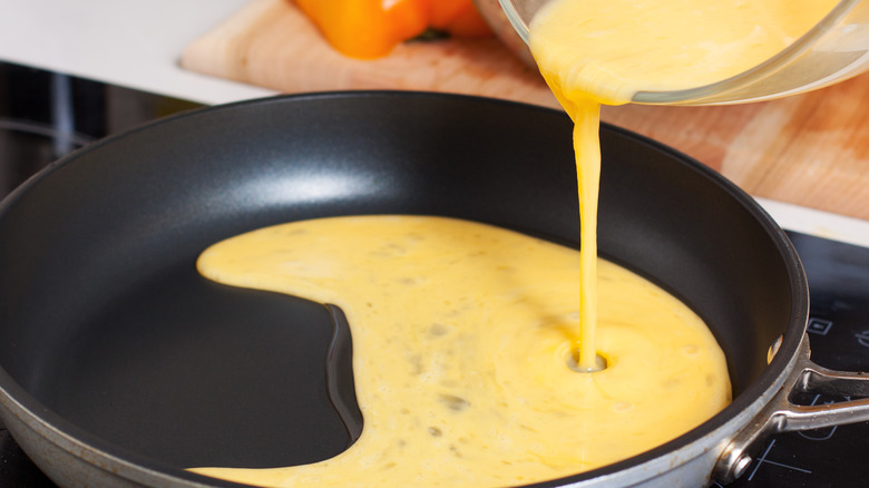 Pouring eggs into pan 