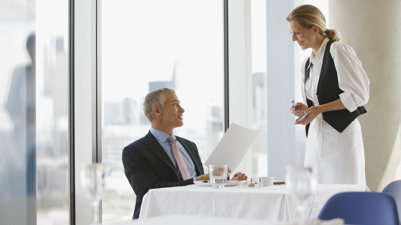 Server with a patron in restaurant