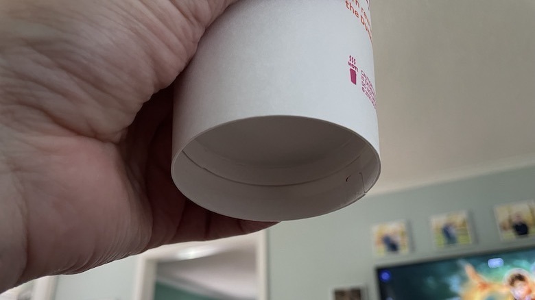 person holding Dunkin' coffee cup