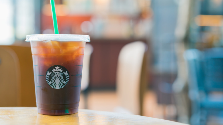 Starbucks iced coffee with green straw on table