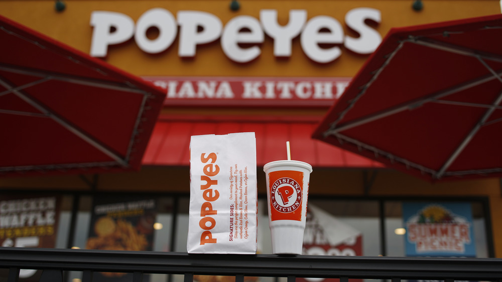 Popeyes takeout meal with restaurant in background