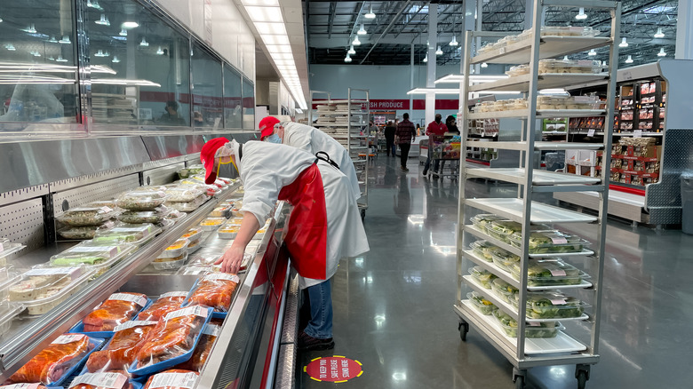 costco workers organizing meat display