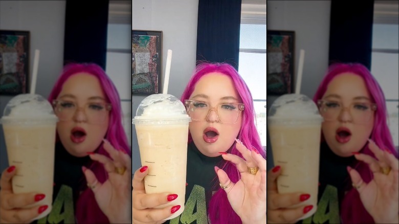 a person holding up a frappuccino