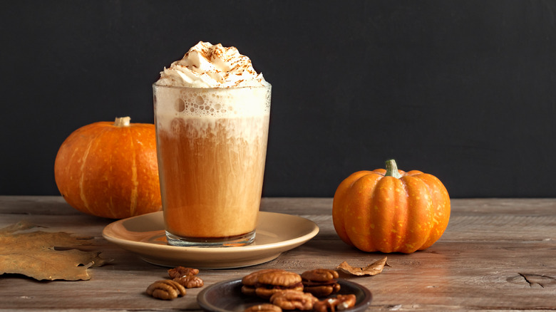 cup of coffee next to pumpkins