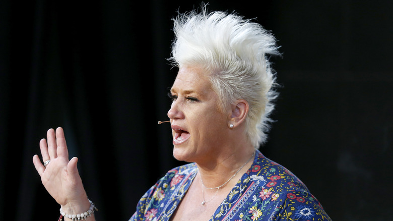 Anne Burrell speaking on stage at an event