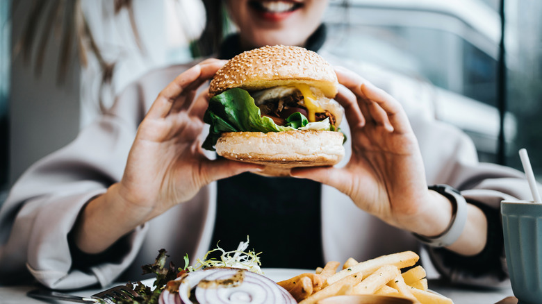 Happily eating a burger