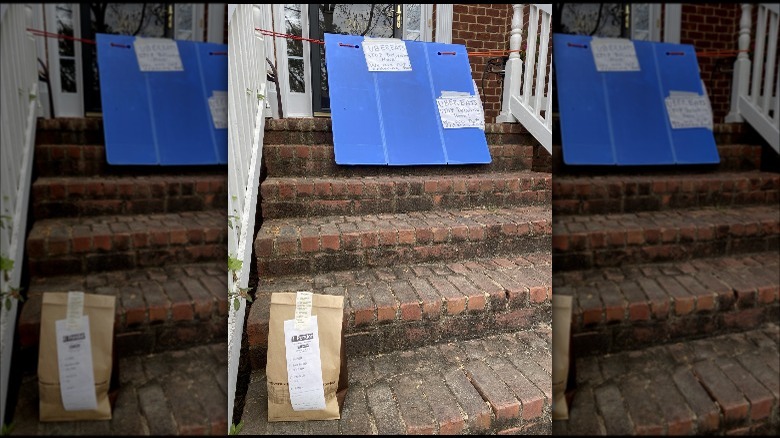 An Uber Eats order on a front step with a blue sign