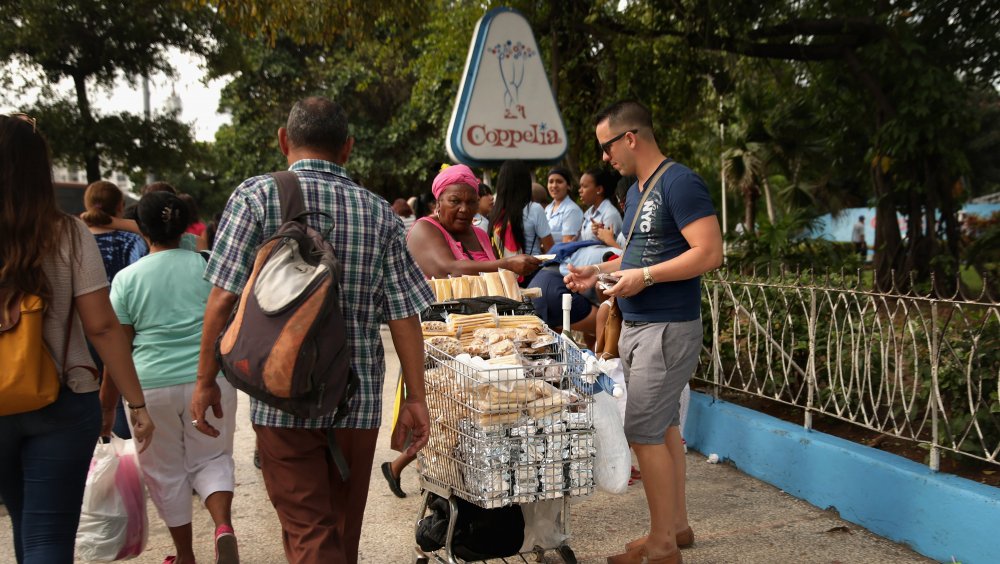 Vendors and pedestrians outside Coppelia, a popular Havana ice cream parlor in Cuba.