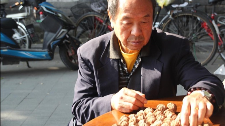 Chinese man sorting walnuts