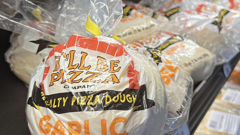 Plastic bag of garlic pizza dough on shelf