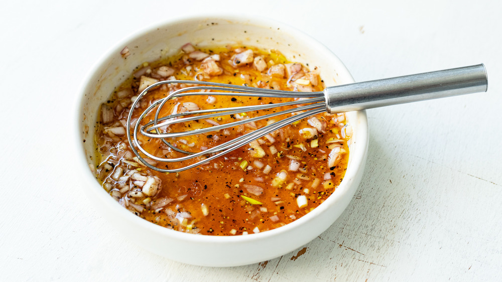 whisking salad dressing in bowl