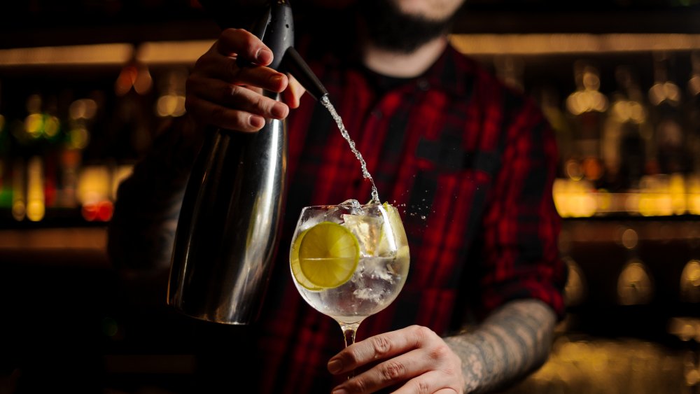 Bartender pouring tonic into G&T