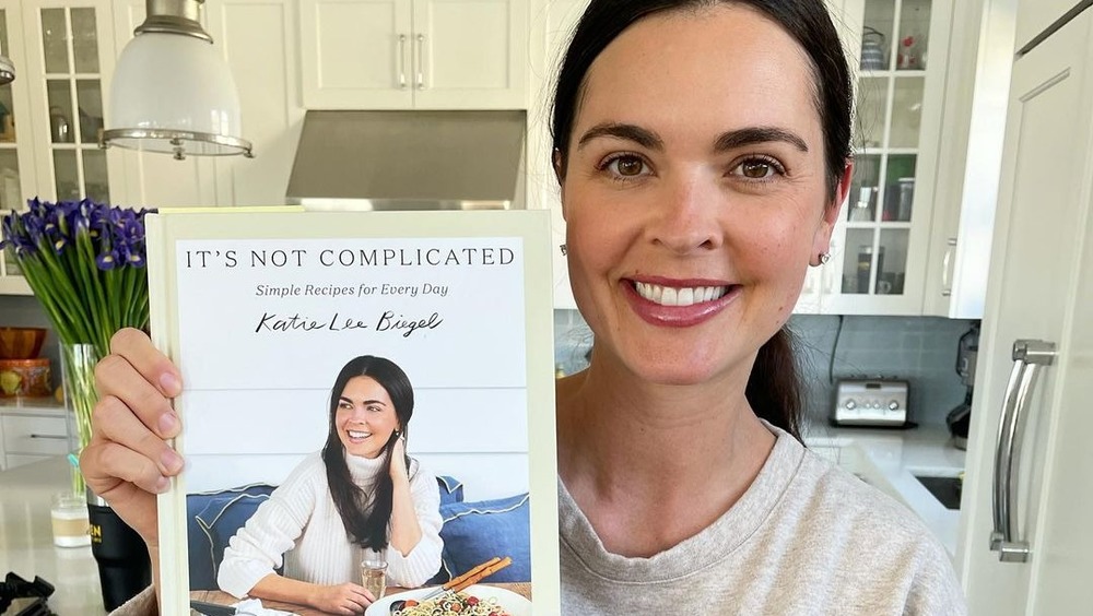 Katie Lee Biegel holding her new cookbook