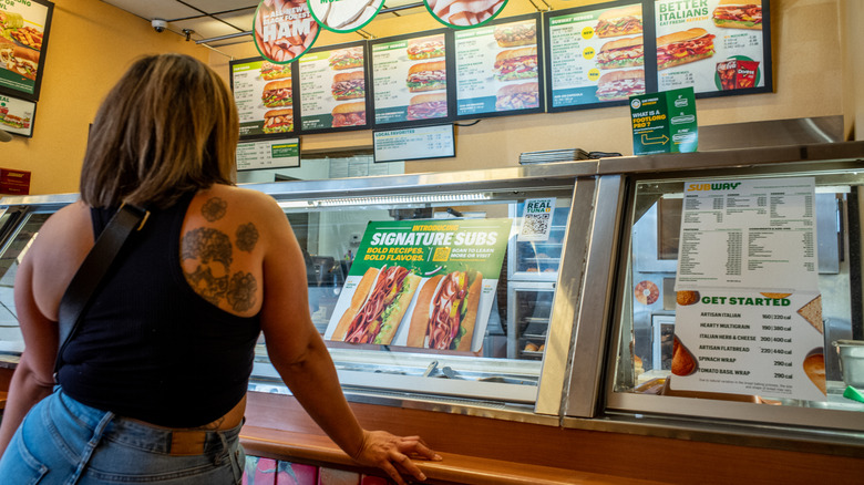 girl standing in front of subway counter