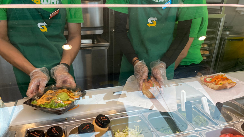 subway workers making subs behind the counter