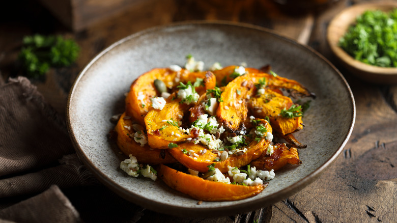 Roasted pumpkin slices with cheese and herbs