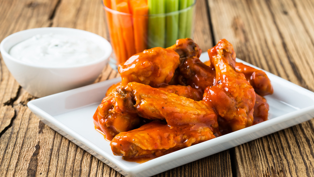 Plate of chicken wings with side of blue cheese, carrots, celery