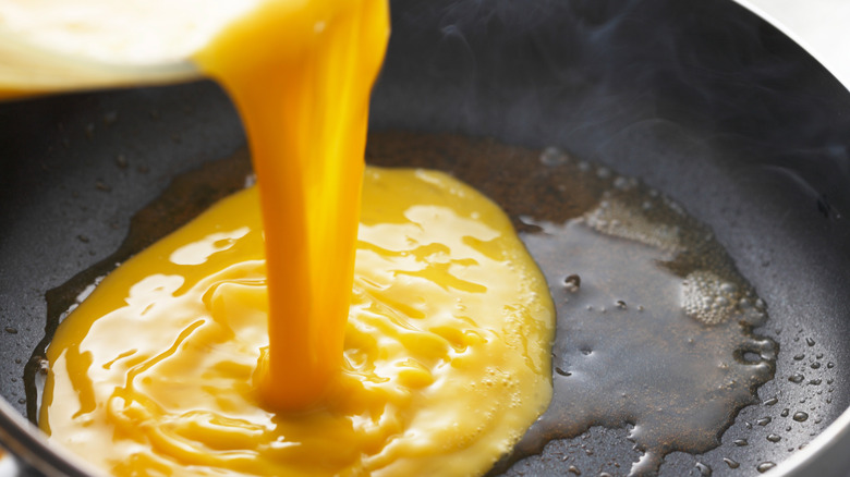 Pouring eggs into omelet pan