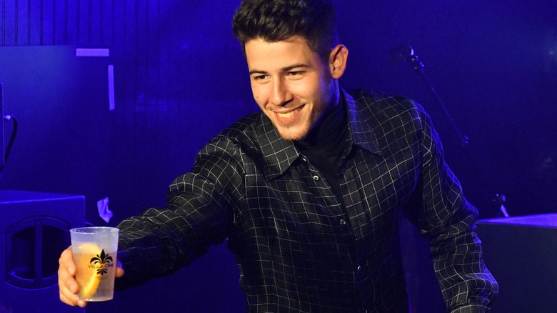 Nick Jonas holding a cocktail with his tequila brand 